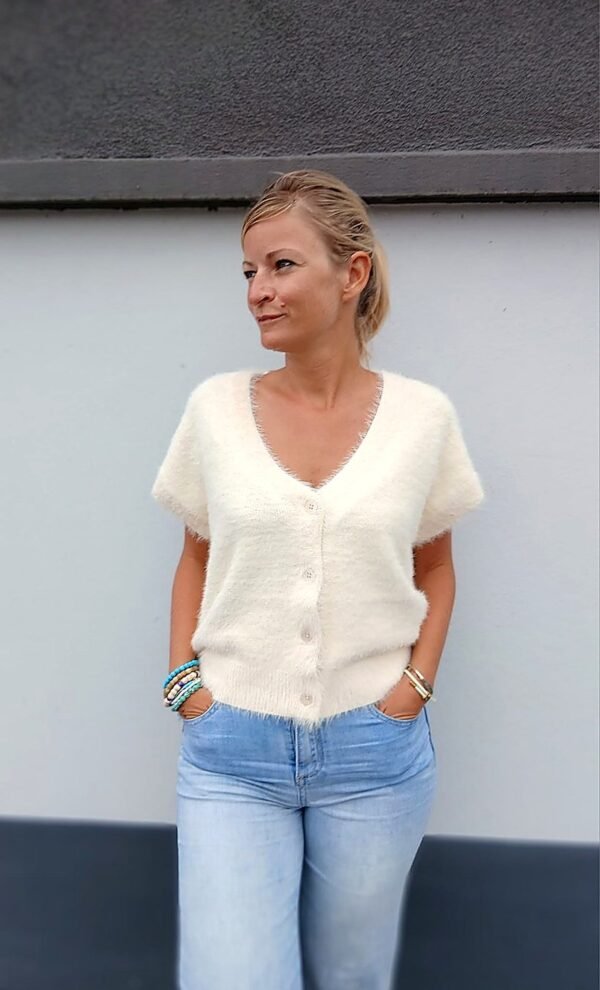 Gilet court crème porté avec un jean large taille haute