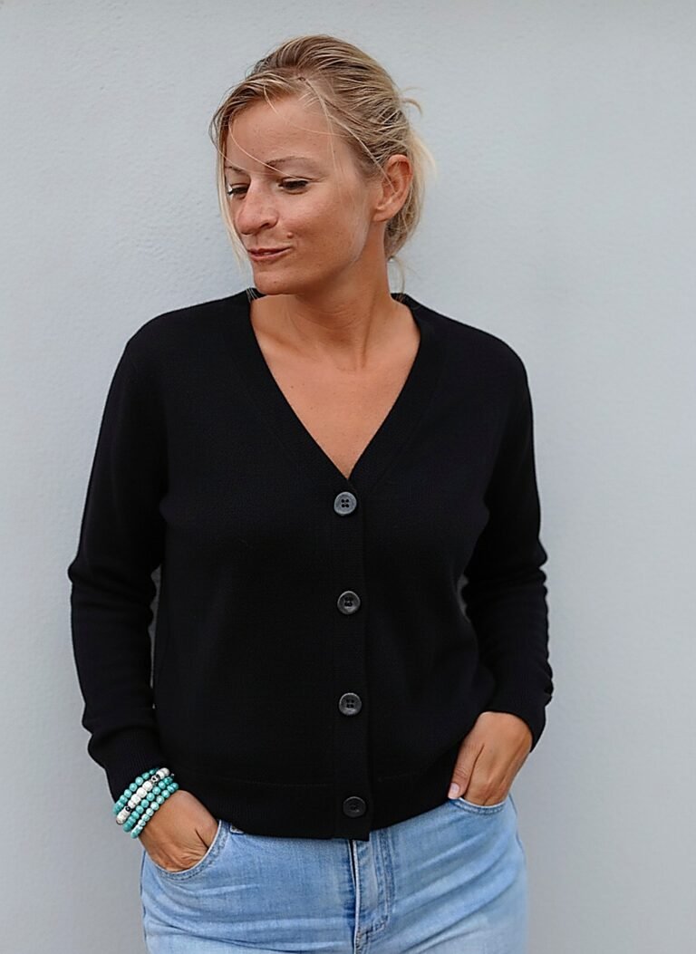 Blazer en maille noir boutonné sur un jean clair : le col V trace une ligne verticale